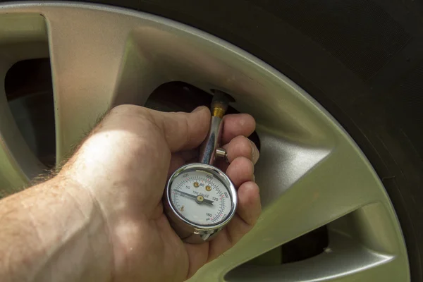 Механик проверяет уровень давления воздуха в шинах — стоковое фото