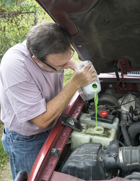 Meccanico che aggiunge il liquido di raffreddamento del motore al veicolo dei clienti — Foto Stock