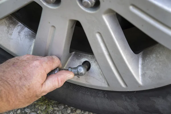 Mechaniker steckt Luft in Autoreifen — Stockfoto