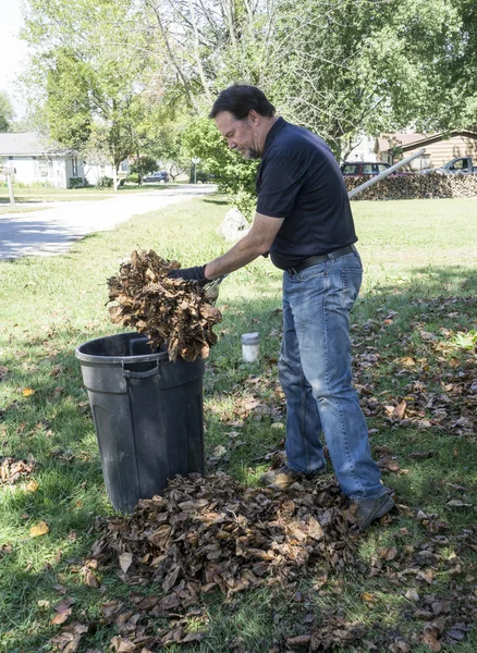 Travailleur mettre des feuilles dans la poubelle — Photo