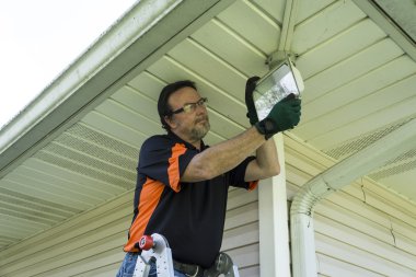 Bir dış ışık fikstür bir ampul değiştirme elektrikçi