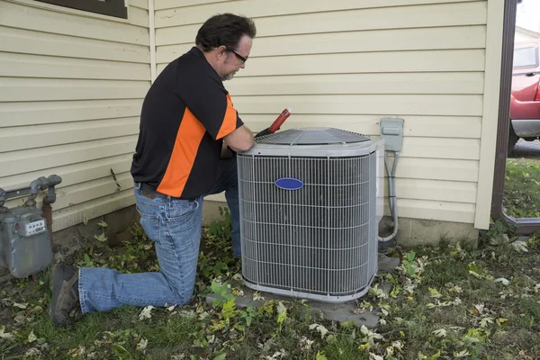 Reparador verificando fora da unidade de ar condicionado para a tensão — Fotografia de Stock