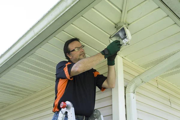 Electrician Taking Defective Bulb Out Of Outside Light Fixture — Stock Photo, Image