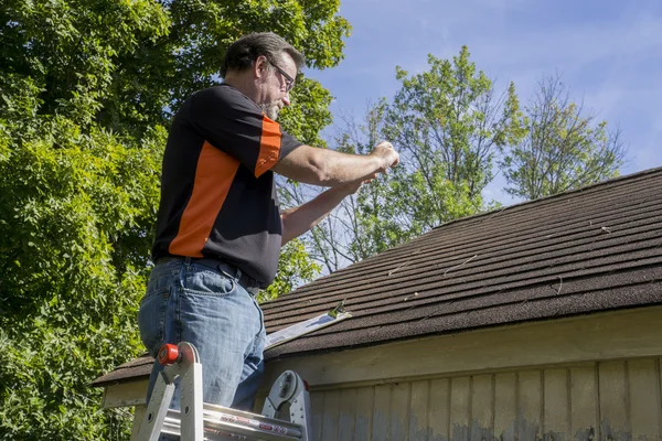 Appaltatore sulla scala che calcola i danni della grandine Riparazioni al tetto — Foto Stock