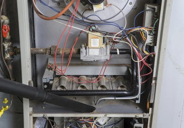 Repairman Vacuuming Inside Of A Gas Furnace — Stock Photo, Image