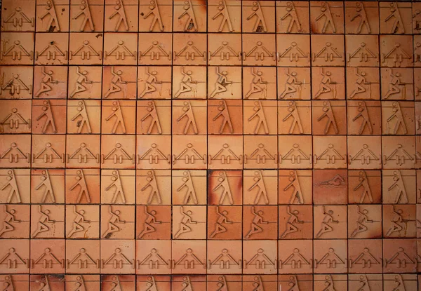 Tuğlaların üzerinde spor resimleri olan tuğla duvar.