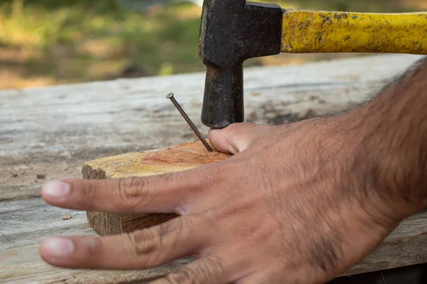 Bir marangozun parmağını çekiçle çekiçlerken bir çivi çakma kazası..