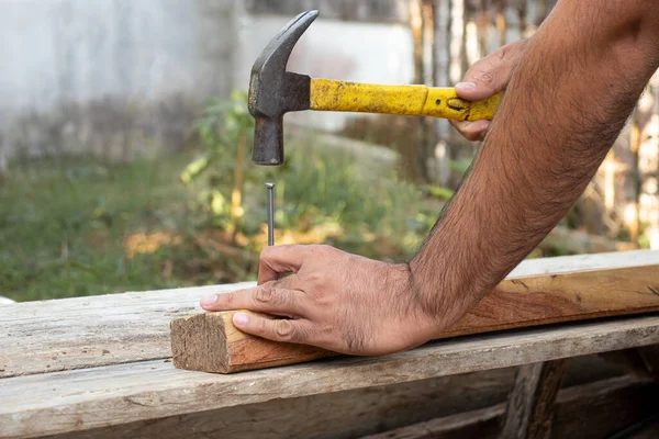 Marangoz çekiçle tahtaya çivi çakıyordu..