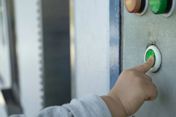 Bebeğin eli su dağıtıcısının başlama düğmesine basıyor..