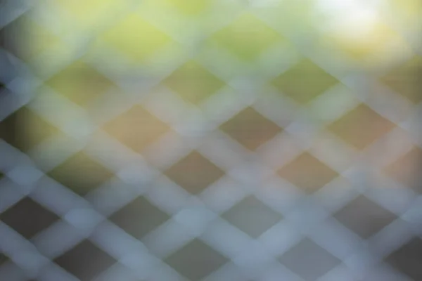 Çelik kafes örgüsüyle soyut bir arkaplan ve bulanık bir doğa..