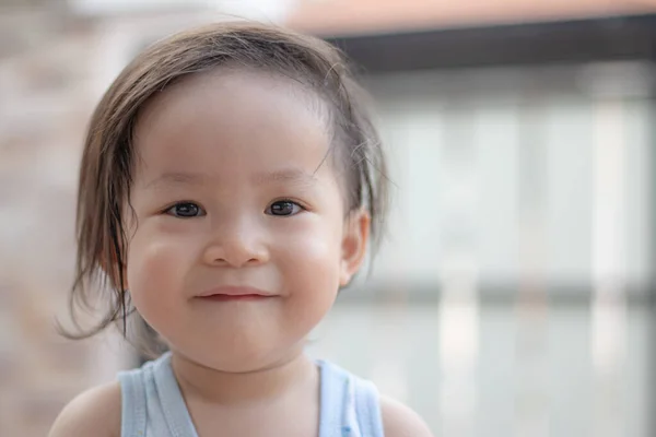 Tatlı tatlı gülümseyen küçük bir kız ve koşmaktan ve oynamaktan sırılsıklam olmuş saçlar..