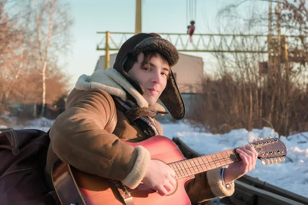 Gitar çalmak kışın adam demiryolu parça