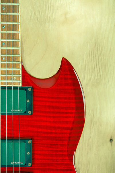 Part of red electric guitar on a wooden background