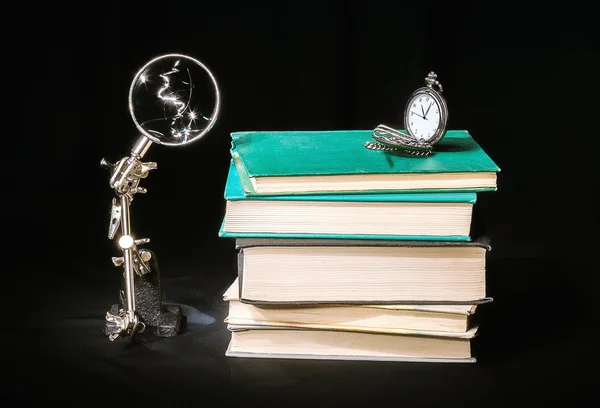 Stilleven met boeken, klokken en vergrootglas — Stockfoto