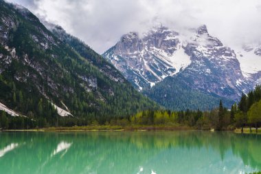 İtalyan Alpleri 'nin arka planında yeşil su olan dağ gölü.