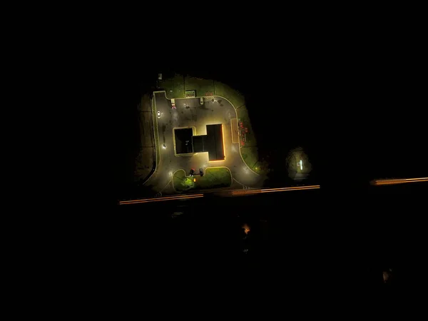 Trafik ışıkları ve çevredeki karanlıkta bir benzin istasyonu.