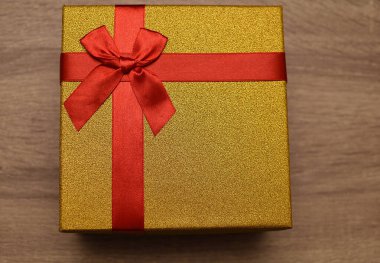 Kırmızı kurdeleli altın bir hediye. Sevdiklerine bir hediye.