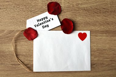 Kırmızı gül, beyaz zarf ve kurdeleler. Sevdiklerine bir hediye.