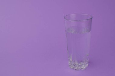 Mor zemin üzerinde su olan cam..