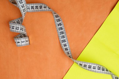 Turuncu ve sarı deri parçaları ve bükülmüş bir santimetre..