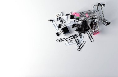 Sabit dur. Ataçlar ve diğer küçük ofis malzemeleri alışveriş sepetinden düştü. Kırtasiye malzemesi satın alma kavramı. İzole et. Uzayı kopyala Düz yatıyordu.