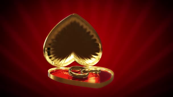 Caja en forma de corazón dorado con anillos de boda — Vídeo de stock