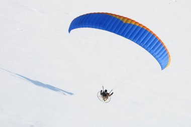 Gros 'un planı Paramotor' un kışın uçması... Ciel 'den görünen kar beyazı bir manzarada.