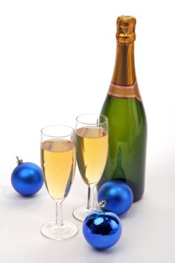 İki kadeh şampanya ve beyaz arka planda izole edilmiş Noel topları.