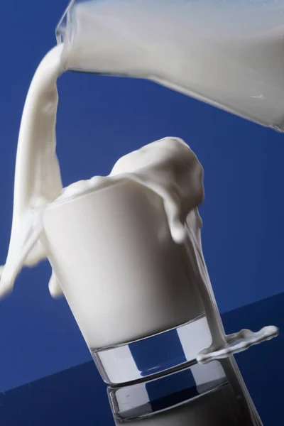 Versare Rapidamente Latte Dalla Caraffa Bicchiere Traboccare Sul Tavolo — Foto Stock