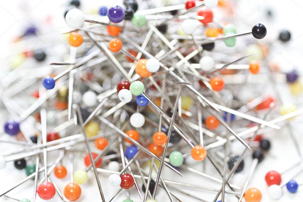 Close up of loose multicolored push pin needles  on white background