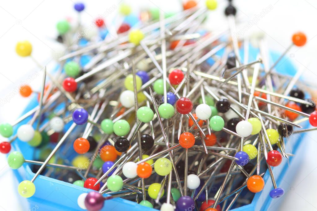 Multicolored dressmaker's needle push pins  box on white background
