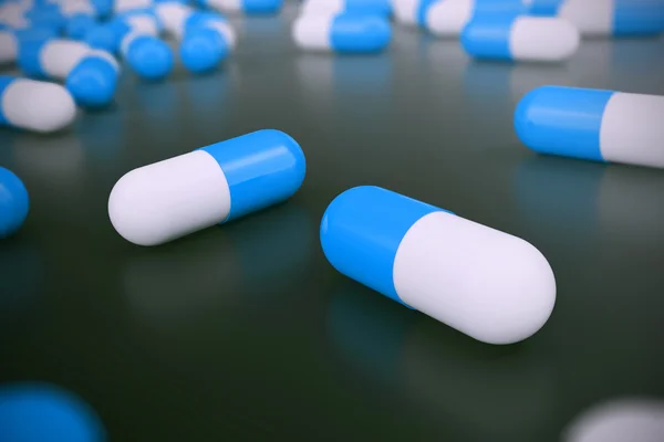 Heap of blue white round capsule pills with medicine antibiotic in packages on black background. 3d illustration — Stock Photo, Image