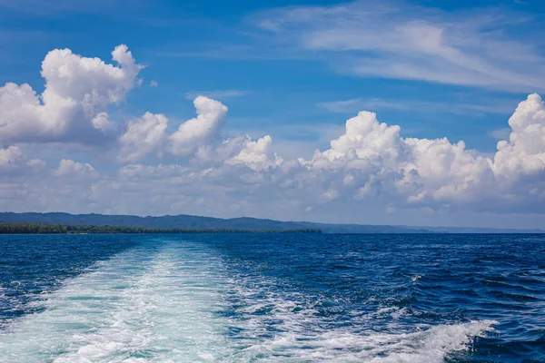 stock image Stormy foam tracks from the sea boat, diverge far into the distance. The motor boat pulled away from the shore at a fast speed.