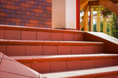 Kahverengi kiremitlerden yapılmış basamaklar. Kulübe verandası