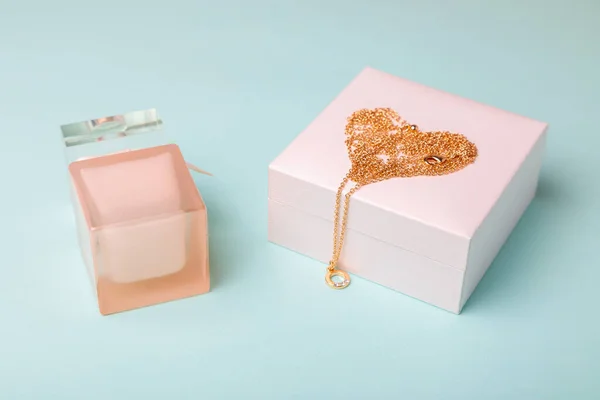 バレンタインデーへの贈り物 ブルーを基調としたゴールドチェーンの香水とボックス ハートの形をした鎖 — ストック写真