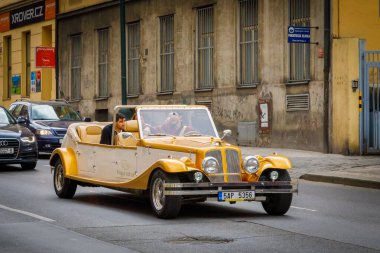 Çek Cumhuriyeti 14 Nisan 2018 Turizm gezileri için klasik arabalar. Turistlerle dolu sarı üstü açık araba..