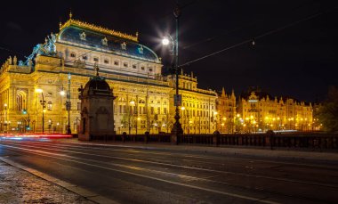 Çek Cumhuriyeti, Prag, 16 Nisan 2016, gece ışıklandırmalı tiyatro binası. Yol boyunca ilerleyen uzun araba ışıkları..