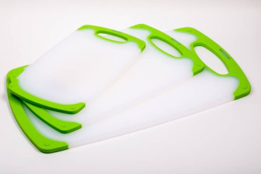 Yemek pişirmek için yeşil saplı beyaz mutfak kesme tahtaları. Yemek, sebze, et, balık kesmek için. Dayanıklı, profesyonel, beyaz plastik..