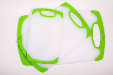 Yemek pişirmek için yeşil saplı beyaz mutfak kesme tahtaları. Yemek, sebze, et, balık kesmek için. Dayanıklı, profesyonel, beyaz plastik..