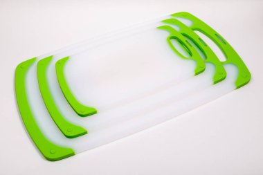 Yemek pişirmek için yeşil saplı beyaz mutfak kesme tahtaları. Yemek, sebze, et, balık kesmek için. Dayanıklı, profesyonel, beyaz plastik..