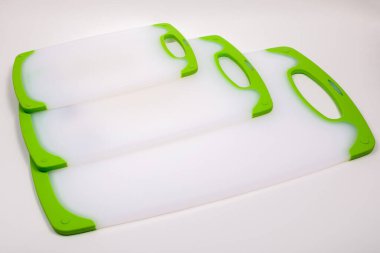 Yemek pişirmek için yeşil saplı beyaz mutfak kesme tahtaları. Yemek, sebze, et, balık kesmek için. Dayanıklı, profesyonel, beyaz plastik..