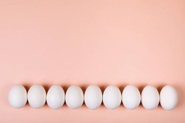 Pembe arka planda paskalya yumurtaları, mesaj için yer var. Bir satırda çeşitli kompozisyonlar, üst, yan, alt.