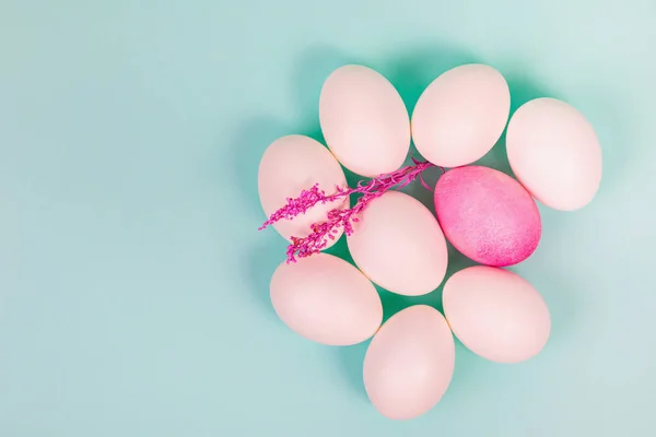 Easter. White eggs with a red egg and a twig on a uniform blue background. Place for text.