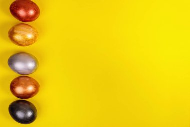 Üniformalı sarı arkaplanlı çok renkli yumurtalar..