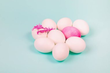 Paskalya. Kırmızı yumurtalı beyaz yumurtalar ve mavi arka planda bir dal. Metin için yer.