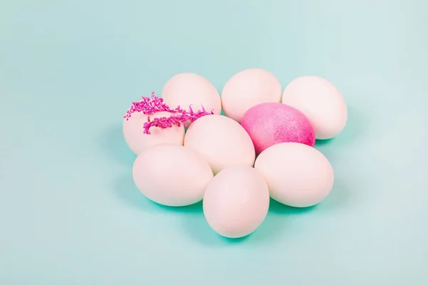 Easter. White eggs with a red egg and a twig on a uniform blue background. Place for text.