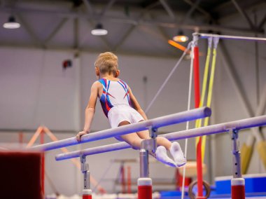 Spor giyim bölümünde küçük bir çocuk düzensiz parmaklıklar üzerinde egzersiz yapıyor..