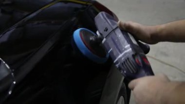 Erkek eller arabayı yumuşak bir disk makinesiyle parlatır. Seçici odak