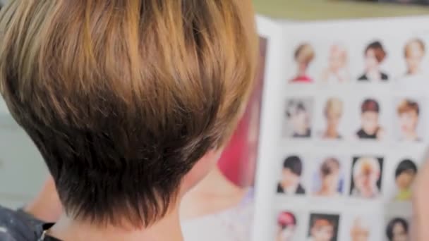 Short Haired Woman Chooses Hairstyle Magazine Close — Stock Video