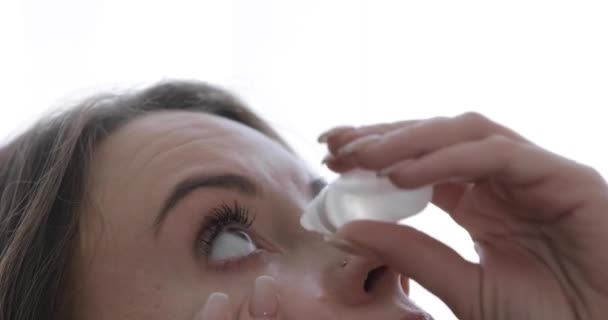 A young girl instills drops of dryness into her eyes — Stock Video